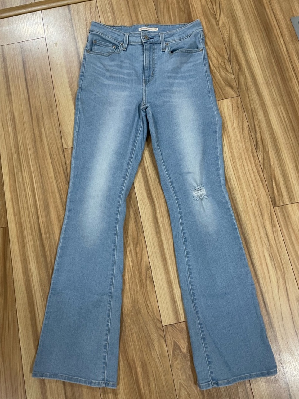 Levi’s 725 High Rise Bootcut Light Blue Jeans with Subtle Distressing.